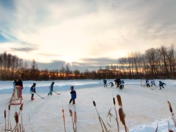 kids playing ice hockey on pond